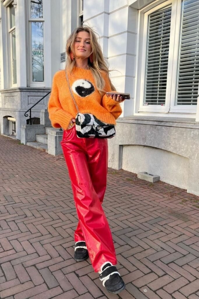 oversized orange sweater with red vinyl pants