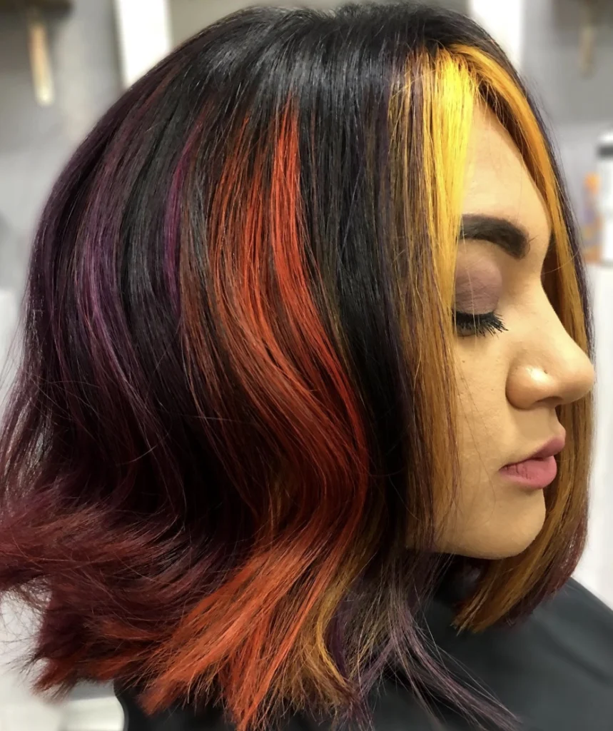 Vibrant Shoulder Length Wavy Hair with Dark Fall Highlights and Bold Color Accents