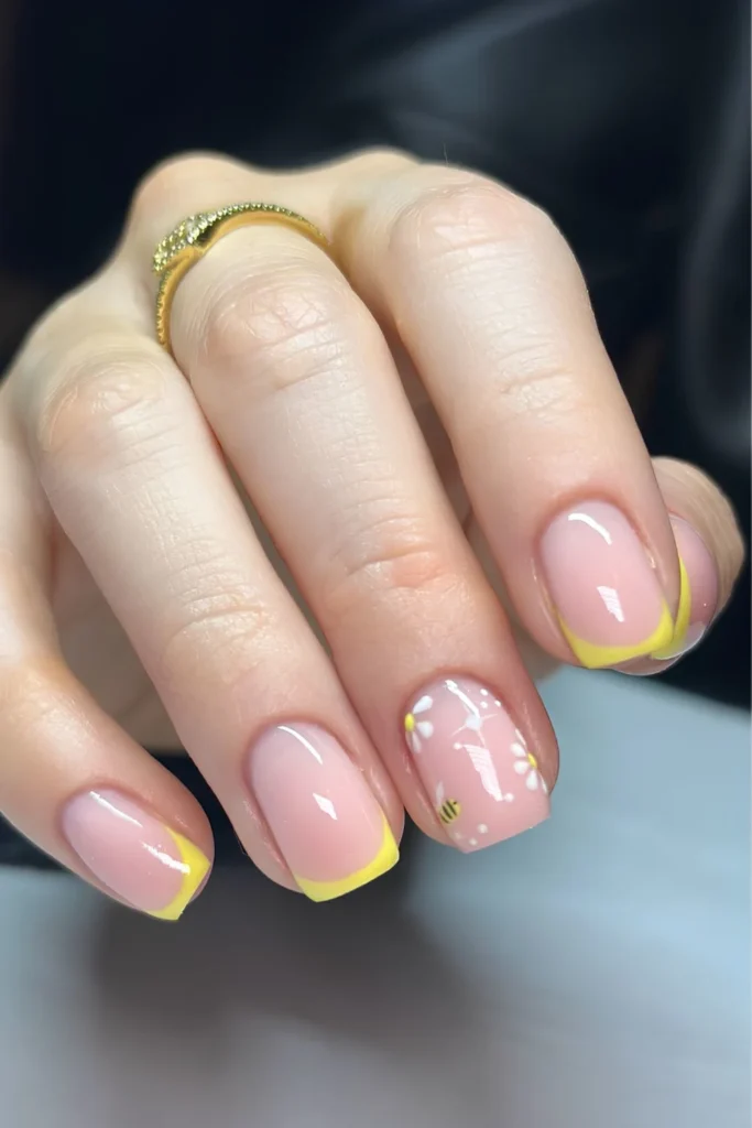 Yellow French tip nails with bees and floral art.jpg