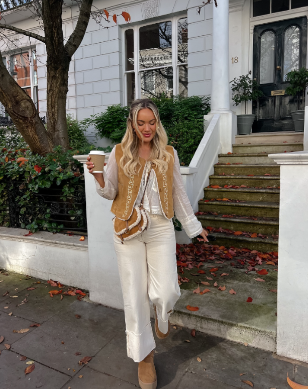 beige vest over a white blouse matching wide leg pants and tan boots