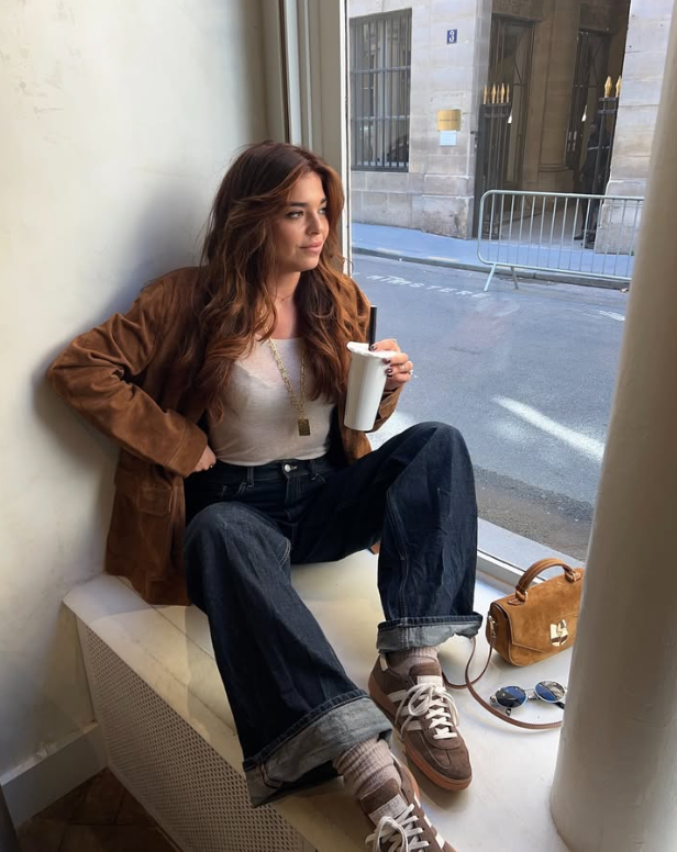 brown suede jacket a white tank top and dark blue cuffed jeans