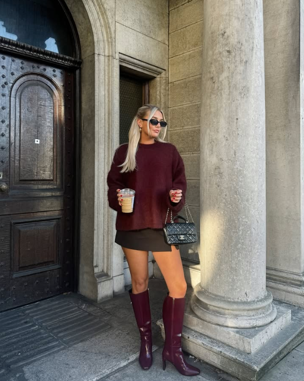 burgundy sweater matching knee high boots and a short black skirt