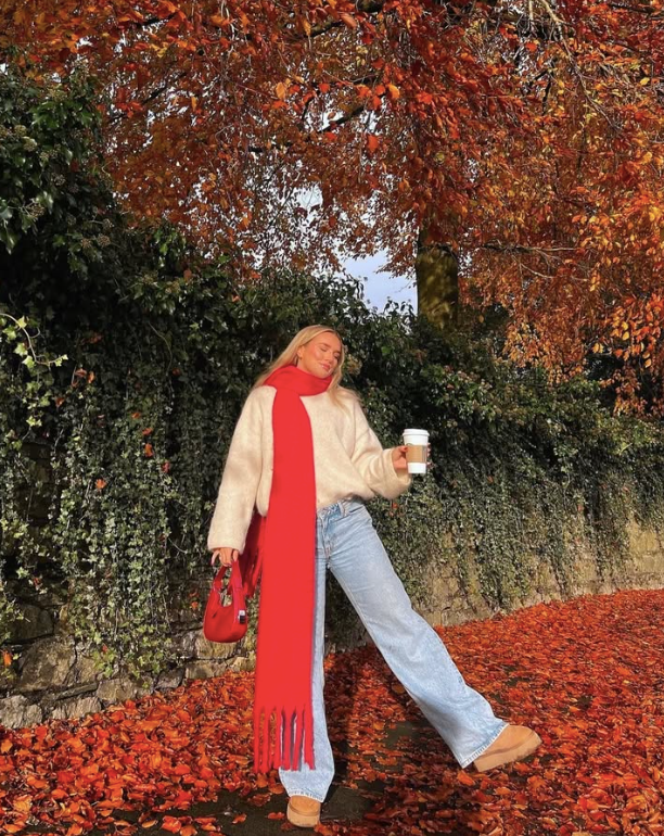 cozy white sweater a long red scarf light blue jeans and tan boots