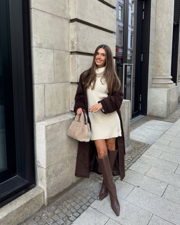 cream turtleneck sweater dress a long dark brown coat and knee high brown boots