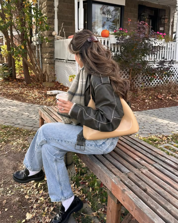 dark leather jacket light blue jeans and black shoes