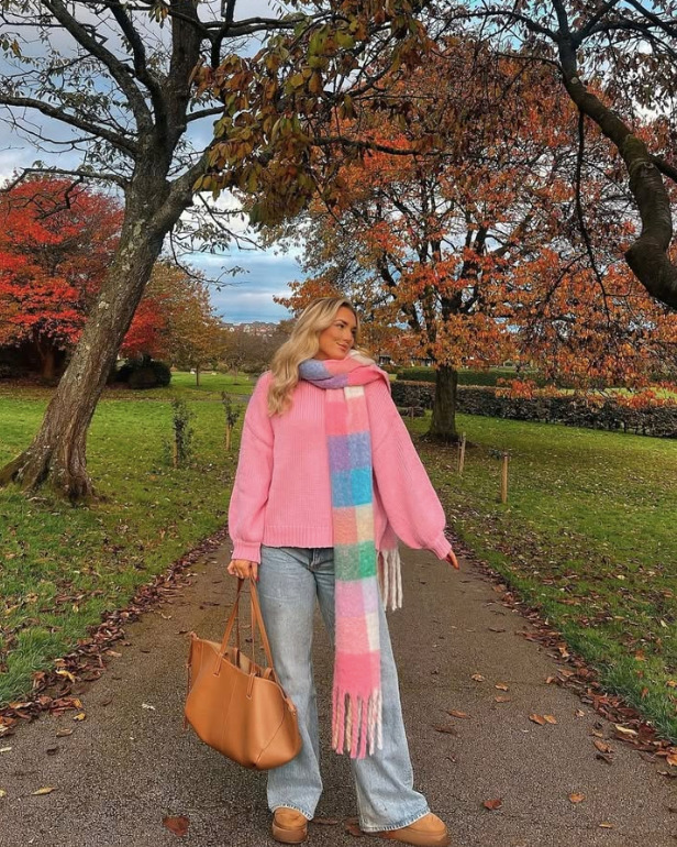 pink sweater a colorful checkered scarf and blue jeans