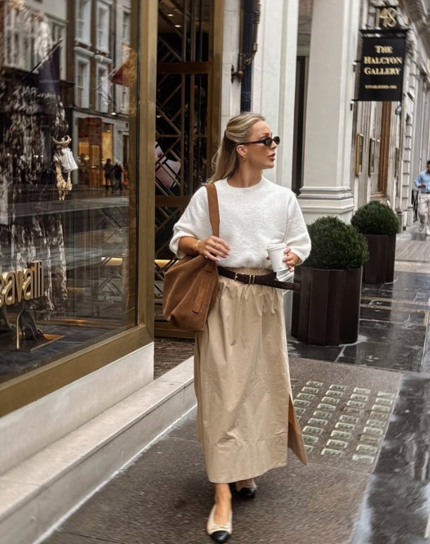 white sweater beige skirt and black sunglasses