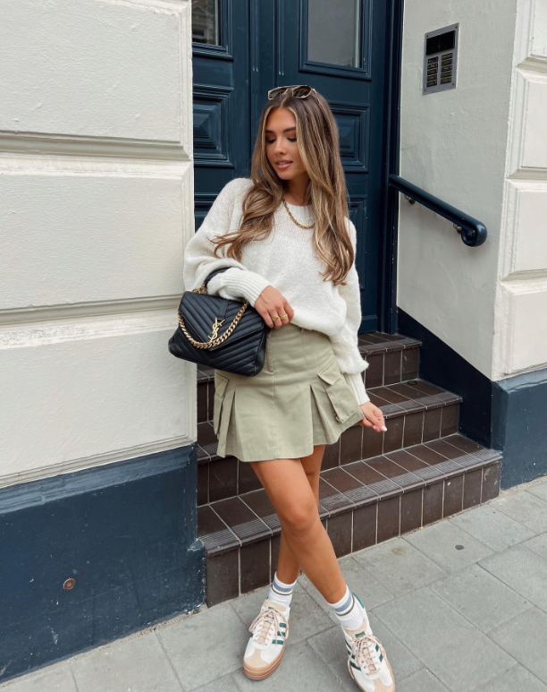 white sweater khaki pleated skirt and sneakers
