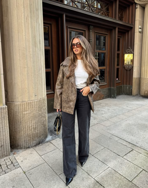 white top a brown jacket and black wide leg pants